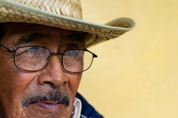 Elder with glasses and hat looking at