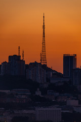 Fototapeta na wymiar Dawn in Vladivostok. The TV tower stands on a hill against the backdrop of a bright dawn