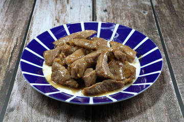 Traditional fried and stirred cutting pork meat with local sauce in Chinese style on the plate. Famous appetizer menu in Asia restaurant. 