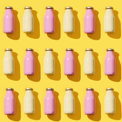 Pattern from small glass bottles for juice or yogurt with dark shadow.