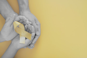 adult and child hands holding yellow gold ribbon, Sarcoma Awareness, Bone cancer, childhood cancer...