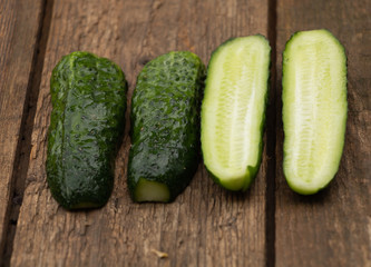 Cucumbers cut in half. on a wooden background. In the process of cooking