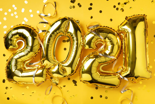 Golden foil balloons made numbers 2021 on yellow background with light bokehs. Happy new year celebration party. Greetings and congratulation concept