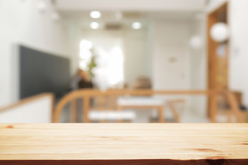 coffee shop blurred background with empty wooden desk montage.