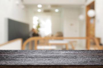 coffee shop blurred background with empty wooden desk montage.