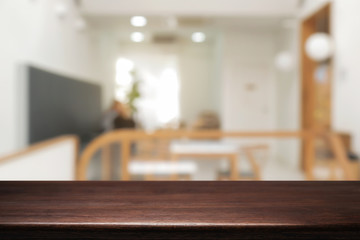 coffee shop blurred background with empty wooden desk montage.