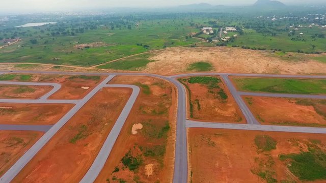 Aerial of interceding roads surrounded by orange dirt and green grass