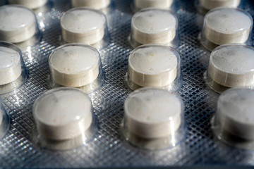 Pharmaceutical medicine pills in blister closeup. Grey tone. High quality photo