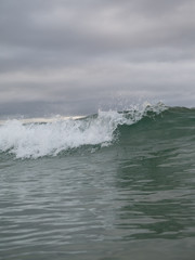Small waves breaking on a surf beach, New Zealand. 