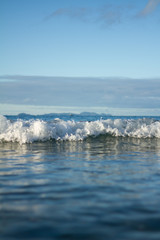 Small waves breaking on a surf beach, New Zealand. 