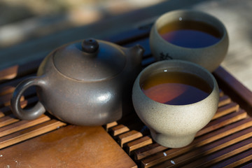Chinese tea ceremony. Ceramic teapot made of clay and bowls on a wooden background.