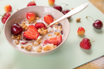 Muesli with fresh fruits and yogurt.porridge with fresh strawberry and cherries.Natural yogurt with fresh berries and muesli. Healthy dessert.Healthy Breakfast with muesli on textured background