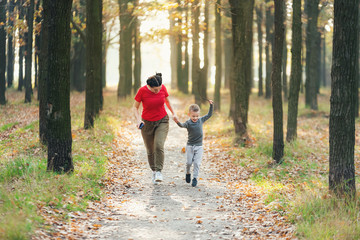 Obraz premium Mom runs with her son in the park
