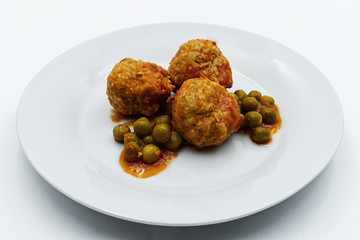 Meatballs with peas in white plate, isolated on white background.