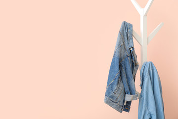 Jeans clothes hanging on rack near color wall