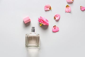 Bottle of floral perfume on light background