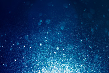 bstract, blue bokeh defocus glitter blur on dark background.