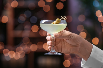 Man with glass of fresh martini in pub