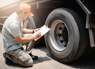 Maintenance and Vehicle inspection. A truck mechanic, driver holding clipboard, his is checking...