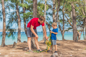 Camping people outdoor lifestyle tourists in summer forest near lazur sea. Blond boy son with...