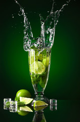 Glass of fresh mojito with splash on dark background