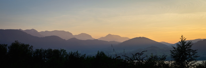 Panoramic view to Austria alps mountain landscape with forest and lake at sunset