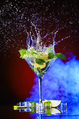 Glass of fresh mojito with splash on dark background