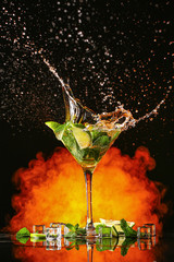 Glass of fresh mojito with splash on dark background