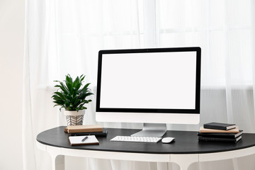 Modern PC monitor on table near window