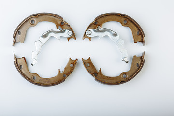 Pair of expanding internal brake shoes isolated on white background. Focus on front one