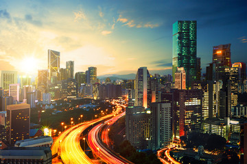 The light trails scenery at the busy highway in modern city during sunset.
