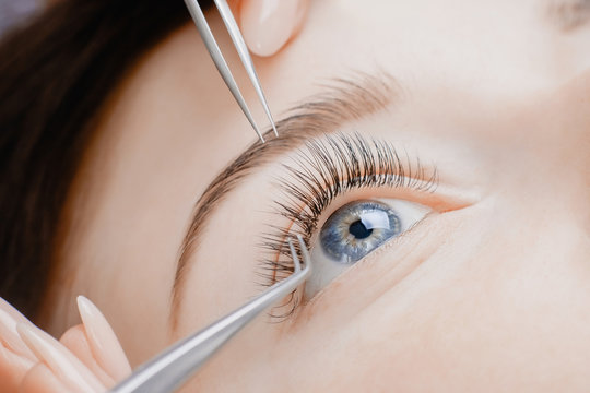 Eyelash extension procedure. Beautiful female eyes with long lashes, closeup