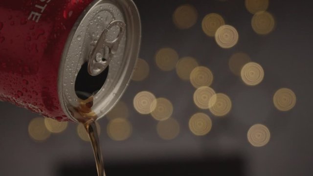 Studio product shot of cold coke pouring in to glass with nice blurred lights in background.