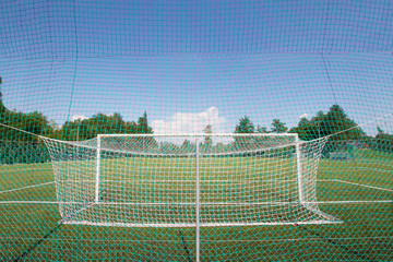Soccer football goal in a large soccer football field. Isolated soccer goal
