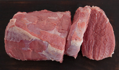 slices of fresh beef on a dark background top view