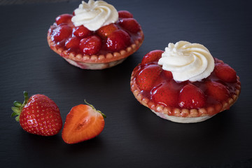 Tartlets with strawberries and whipped cream, close up