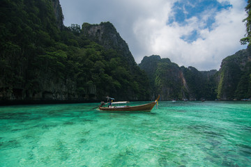 Plakat wood Boat in Crystal clear sea water at Ao Pi Leh is snorkeling point famous tour lagoon in Phi Phi Islands, Krabi