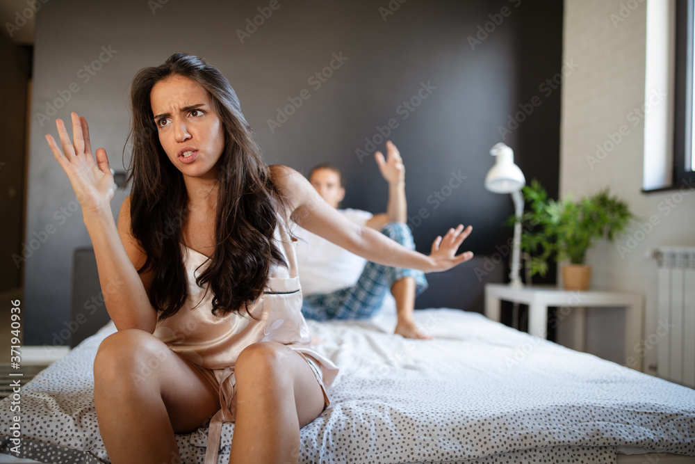 Wall mural Young couple in bed having problems and crisis. Divorce and separation