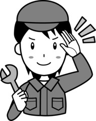 スパナを持って敬礼する、作業服姿の男性スタッフ