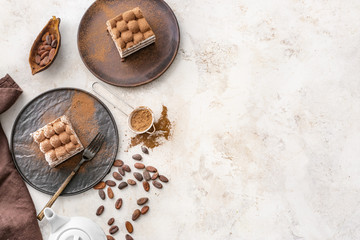 Plates with tasty tiramisu on light background
