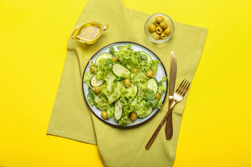 Plate with tasty cucumber salad on color background