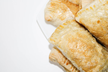 Fresh baked puff pastries on a white plate. Rich pastries on the table.