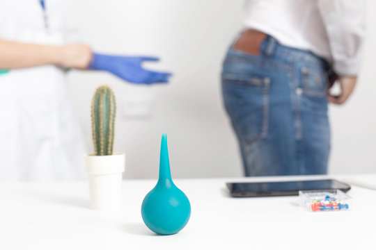 Doctor proctologist puts on medical gloves for a digital examination of the patient s rectum for diseases of the hemorrhoids and anal fissures, background