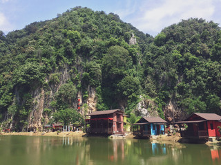 Fototapeta na wymiar Beautiful landmark that surrounded by mountains and green facing clearly reflective lake in Ipoh, Malaysia.