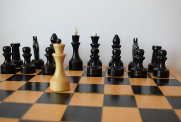 The white king with the black chess pieces on a chess board