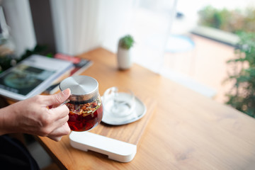 woman hand holding tea pot in cafe