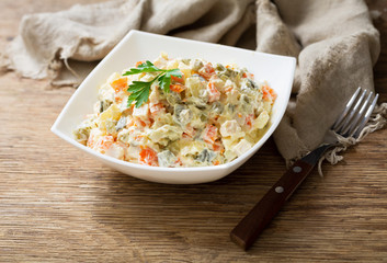 bowl of russian salad olivier with meat and vegetables