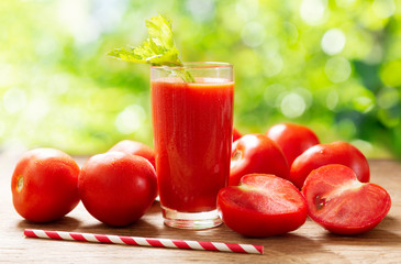 glass of tomato juice with fresh tomatoes on wooden table