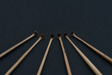Handmade bamboo ear wax remover on black background.