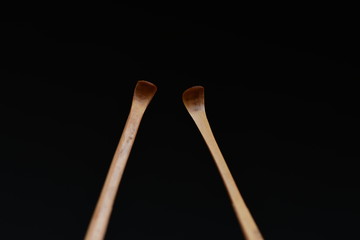Handmade bamboo ear wax remover on black background.